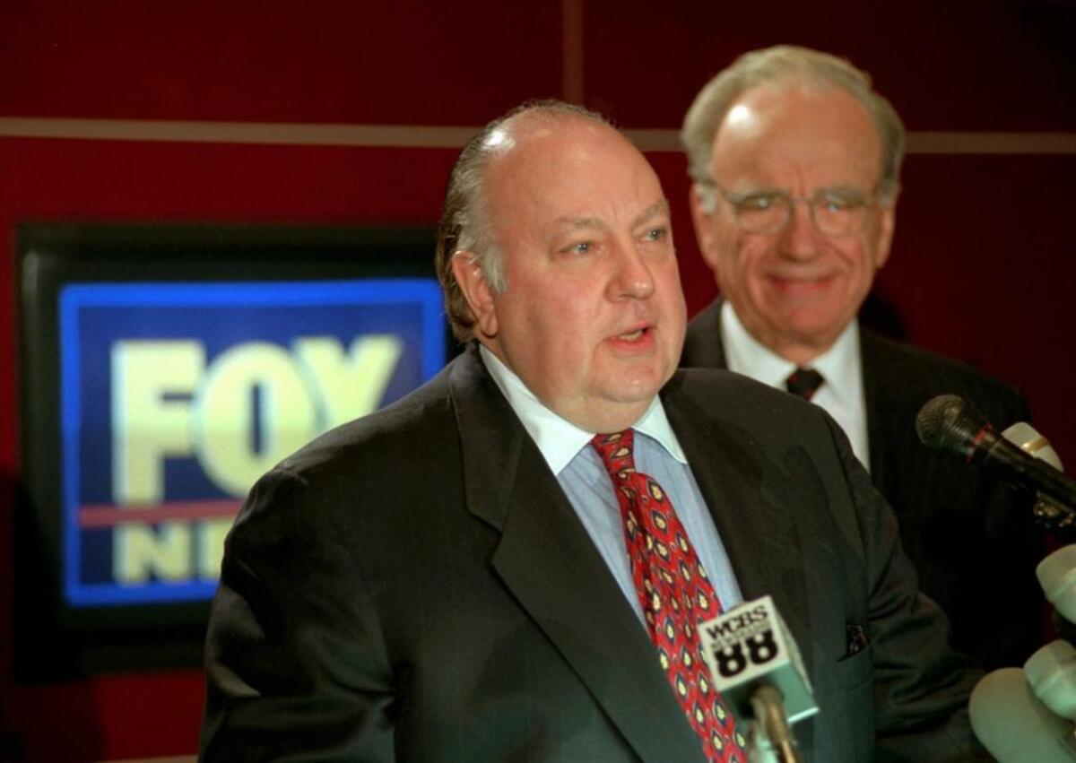 Roger Ailes, left, speaks at a 1996 news conference as Rupert Murdoch looks on after it was announced that Ailes would be chairman and CEO of Fox News. Murdoch – who concluded when he first met Ailes that "Either this man is crazy or he has the biggest set of b-- I've ever seen" – asked him to launch a conservative alternative to CNN.