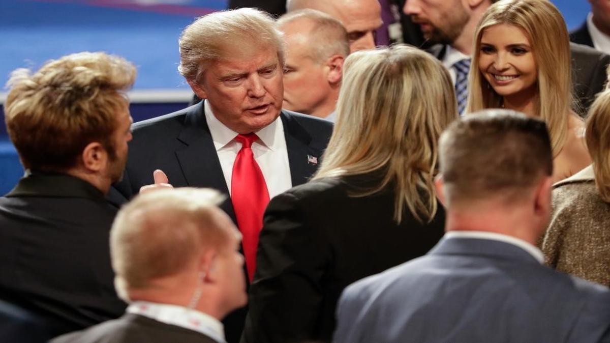 Republican presidential nominee Donald Trump talks with members of the audience Wednesday, Oct. 19, 2016, after the third presidential debate, in which he claimed credit for NATO defense spending increases by U.S. allies.