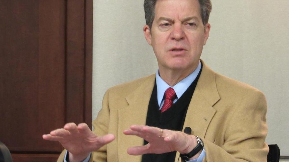 Gov. Sam Brownback unveils a new mentoring program for welfare recipients at a meeting of the Social Services Policy Council.