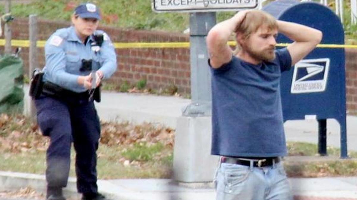 FILE- In this Dec. 4, 2016, file photo, Edgar Maddison Welch, 28 of Salisbury, N.C., surrenders to police in Washington. Welch, who fired an assault riffle multiple times inside a pizza restaurant in the nation's capital while investigating an internet conspiracy theory is expected in court Tuesday, Dec. 13, for a hearing on whether he should stay in jail while he awaits trial.