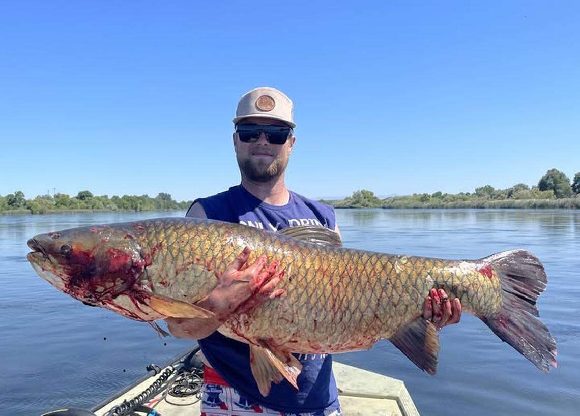 Riley Farden is pictured holding the 67.65-pound grass carp.