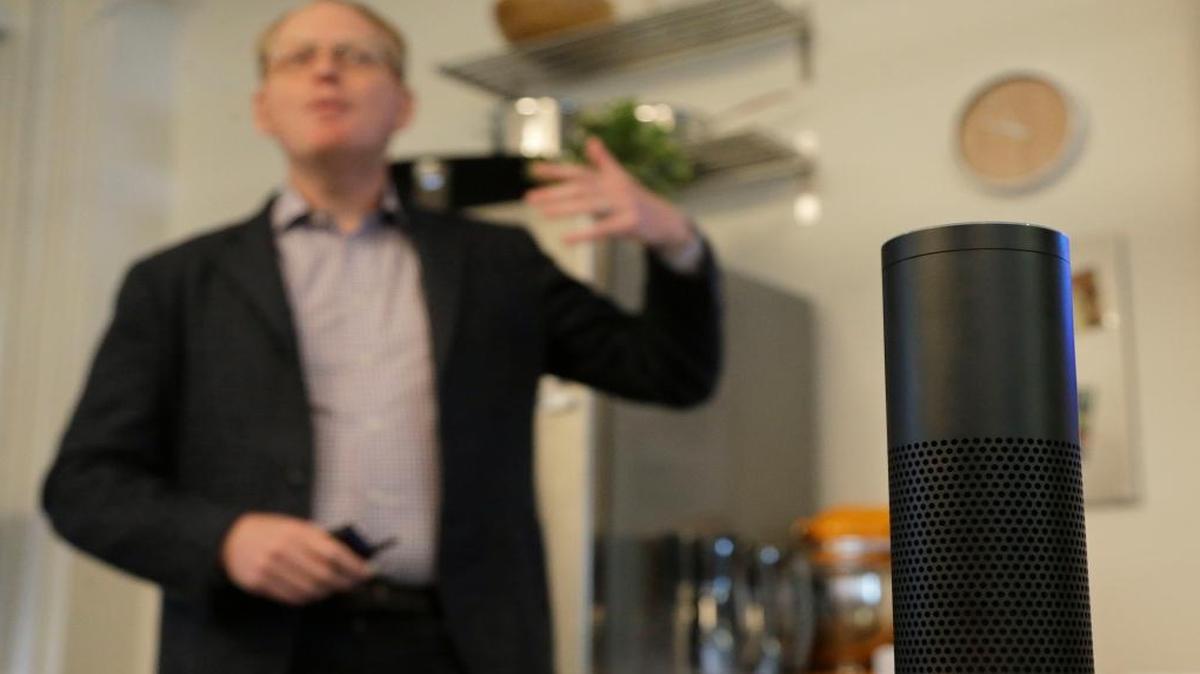 David Limp, Amazon senior vice president of devices, speaks behind an Amazon Echo in San Francisco. Amazon Echo is a hands-free unit with seven microphones that responds to requests for information or action, such as calling a taxi or giving a weather report.
