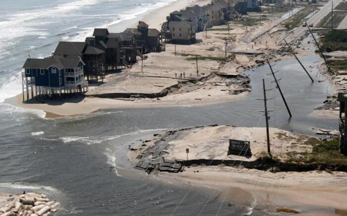 Floodwaters cut a roadway on Hatteras Island, N.C., in five places on Aug. 28, 2011, after the area took a wallop from Hurricane Irene. Flooding is expected to worsen due to a rise in sea levels that scientists blame on global warming.