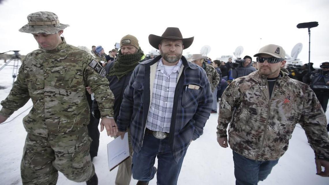 Ammon Bundy, center, one of the sons of Nevada rancher Cliven Bundy, walks off after speaking with reporters during a news conference at Malheur National Wildlife Refuge headquarters Monday near Burns, Ore.