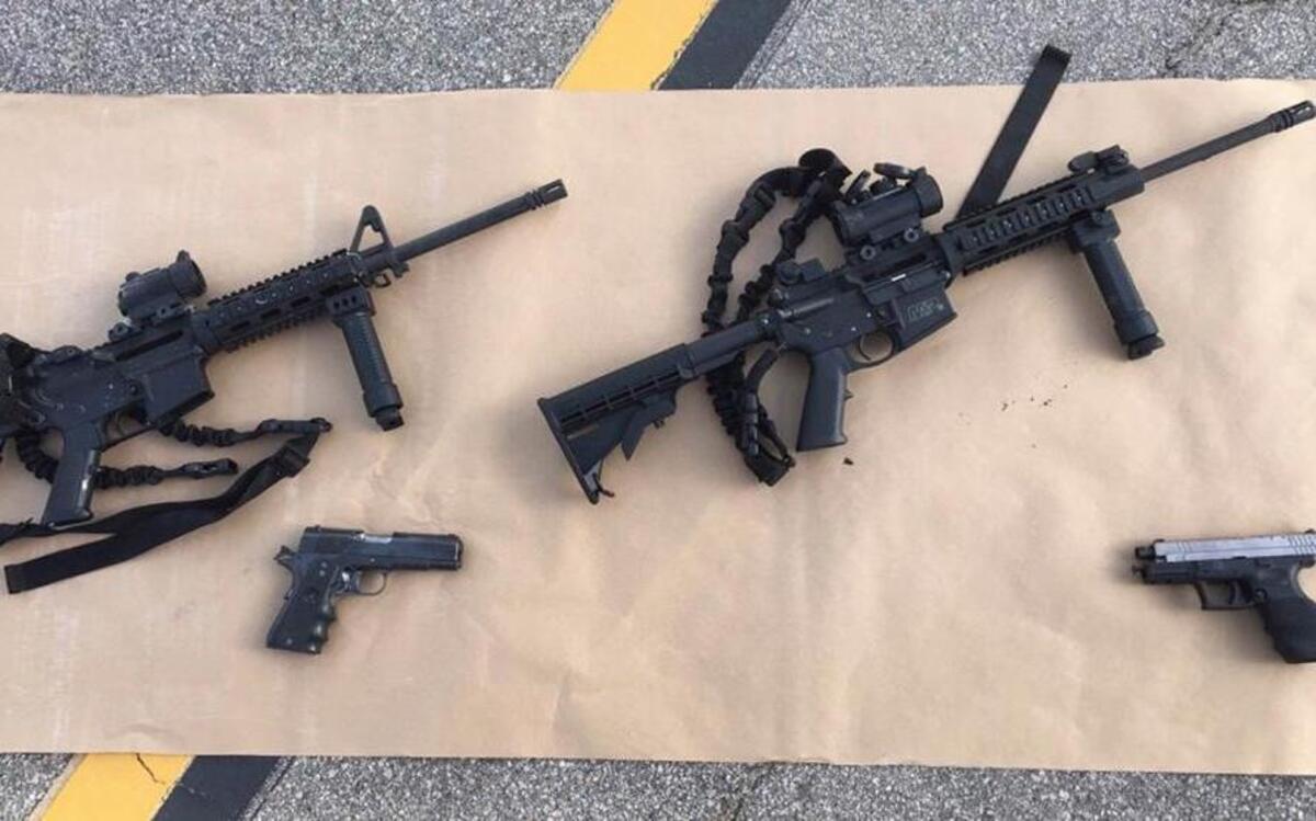 In a photo provided by the San Bernardino County Sheriff’s Department, the weapons police say were used by suspects in last week’s mass killings in San Bernardino are displayed during Gov. Jerry Brown’s news conference held outside the site, Dec. 3, 2015. The semi-automatic rifles, variants of the popular AR-15, were reportedly purchased legally despite the state’s strict gun laws.