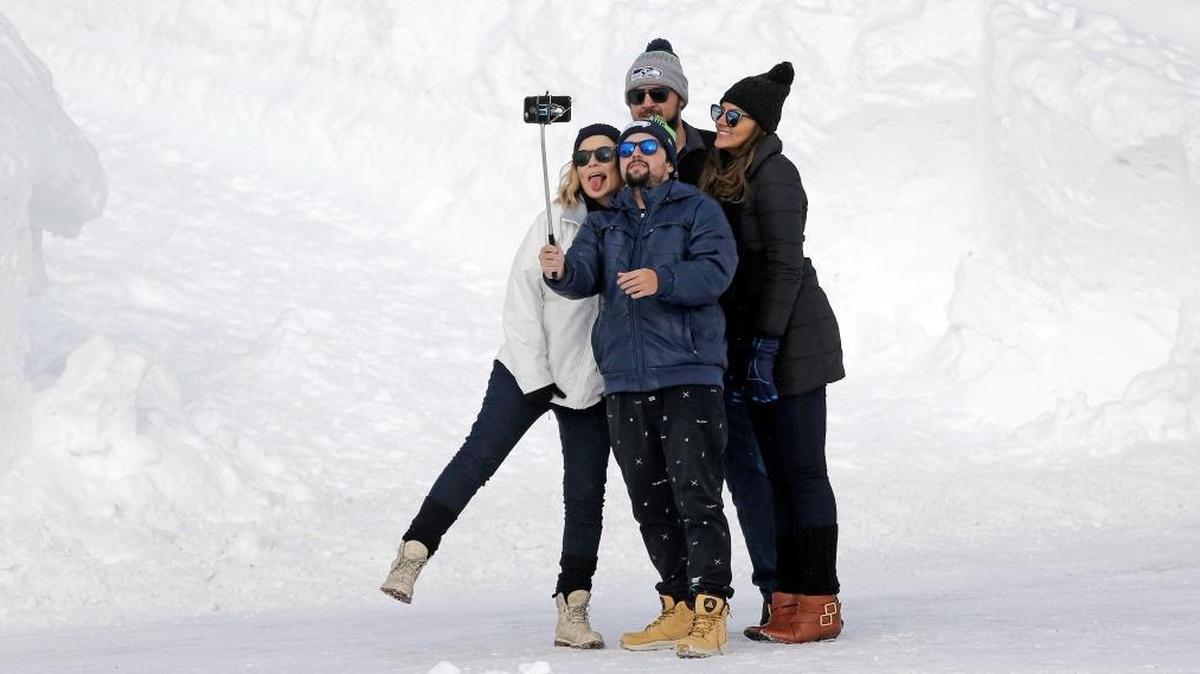 Visitors pose for a selfie on Dec. 16, 2016 in Mount Rainier National Park in Washington state. Mount Rainier and other national parks are weighing plans to expand cellular coverage in once remote areas. First responders support the plans, as do some park officials, who argue that better cell coverage will help attract a new generation of visitors. Critics fear it will lead to more noisy distractions in places designed to be an escape from the modern world.