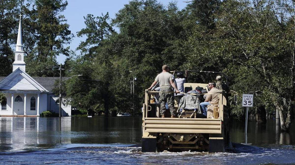 A National Guard high-water vehicle drives through Nichols, S.C. on Tuesday, Oct. 11, 2016. About 150 people were rescued by boats from flooding in the riverside village of Nichols on Monday.