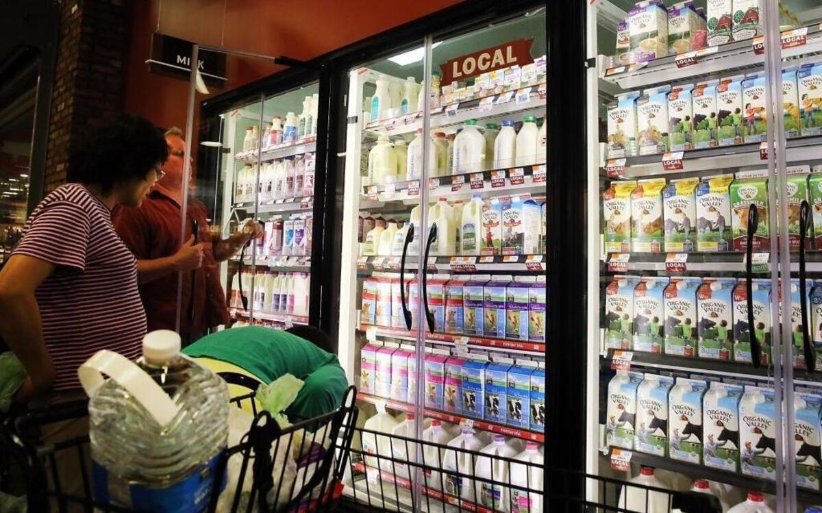 A customer shops for milk in a Brooklyn supermarket in New York City, N.Y., on June 9, 2014. Due to record-low milk prices, family-owned dairy farms across the country are suffering significant loss.