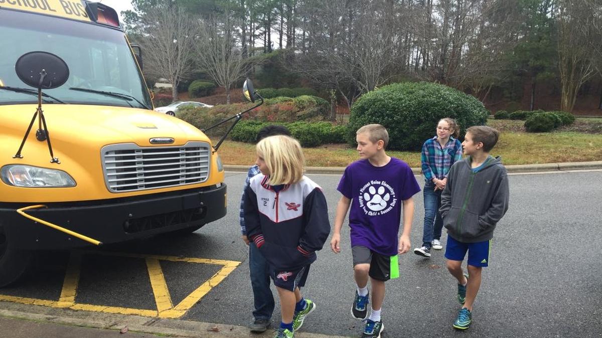 Fifth-graders at Pleasant Union Elementary School in North Raleigh demonstrate how students will cross the street to board buses with new state-mandated hand signals.