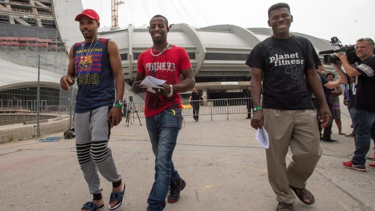 Asylum seekers from Haiti leave Olympic Stadium Thursday in Montreal. The stadium is being used as temporary housing for the influx of asylum seekers arriving from the United States.