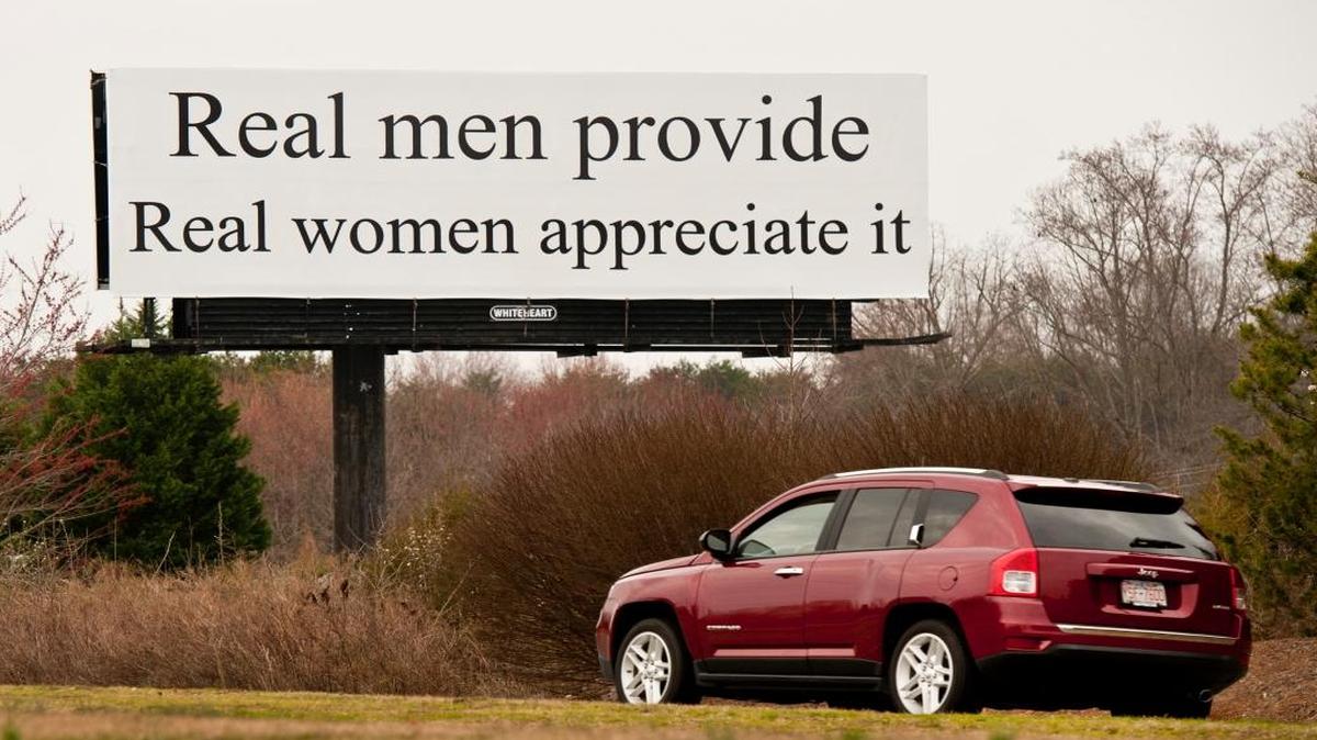 A billboard on Bus. 40 near the Linville Road exit states "Real men provide Real women appreciate it".