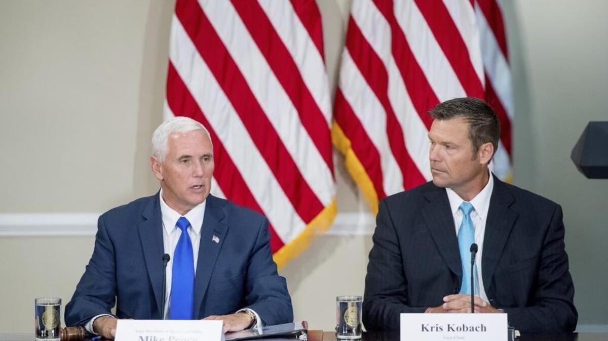 Vice President Mike Pence, left, accompanied by Vice-Char Kansas Secretary of State Kris Kobach, speaks during the first meeting of the Presidential Advisory Commission on Election Integrity at the Eisenhower Executive Office Building on the White House complex in Washington, July 19, 2017. A conservative legal group has threatened to sue California Secretary of State Alex Padilla over the issue of inactive voters.