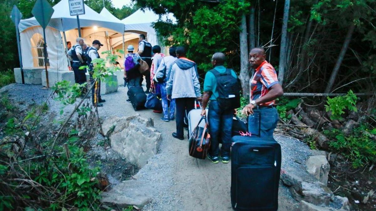 Haitian migrants living in the U.S. prepare to cross the U.S. and Canadian border along Roxham Road on Friday, Aug. 11, 2017. Thousands of Haitians have crossed over into Canada from an irregular crossing near the Champlain-Saint-Bernard-de-Lacolle border in hopes of finding residency in Canada.