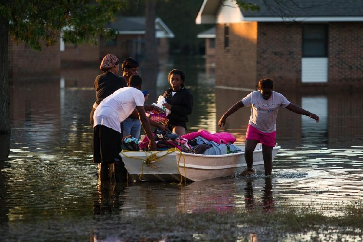 Residents return from checking their homes after Hurricane Matthew caused downed trees, power outages, a municipal water outage and widespread flooding along the Lumber River Thursday, October 13, 2016 in Lumberton, NC.