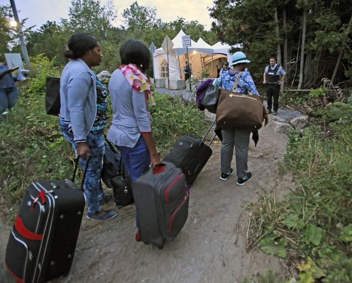 Haitian migrants living in the US prepare to cross the US and Canadian border along Roxham Road on Friday, August 11, 2017. Thousands of Haitians have crossed over in to Canada from an irregular crossing near the Champlain-St. Bernard de Lacolle border in hopes of finding residency in Canada.
