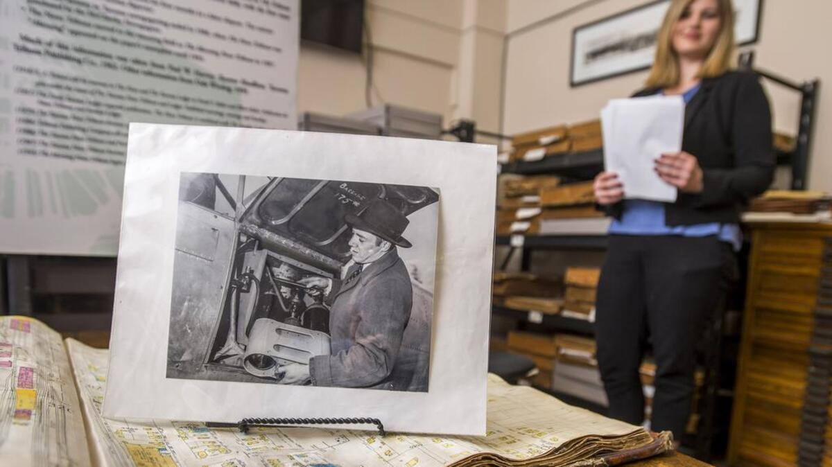 Nichole Hine, a research intern at the Tacoma Historial Society, shows a 1947 photo of College of Puget Sound's Dr. Robert Sprenger with a rainmaking machine he built.