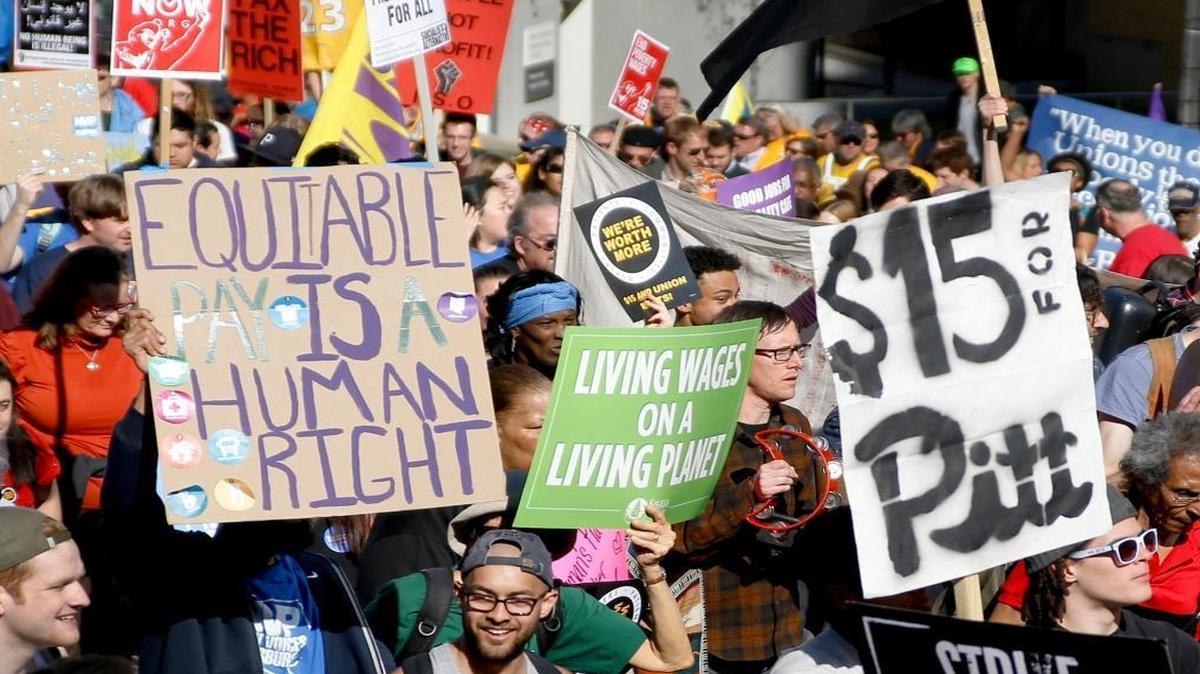 In this April 14, 2016, file photo, union organizers, students and supporters for a $15 an hour wage march through the Oakland section of Pittsburgh. Modest income growth for most Americans, strikes by fast-food workers and the rapid growth of low-paying jobs at the same time that middle-income work shrinks combined to make the minimum wage a top economic issue for the 2016 political campaigns.