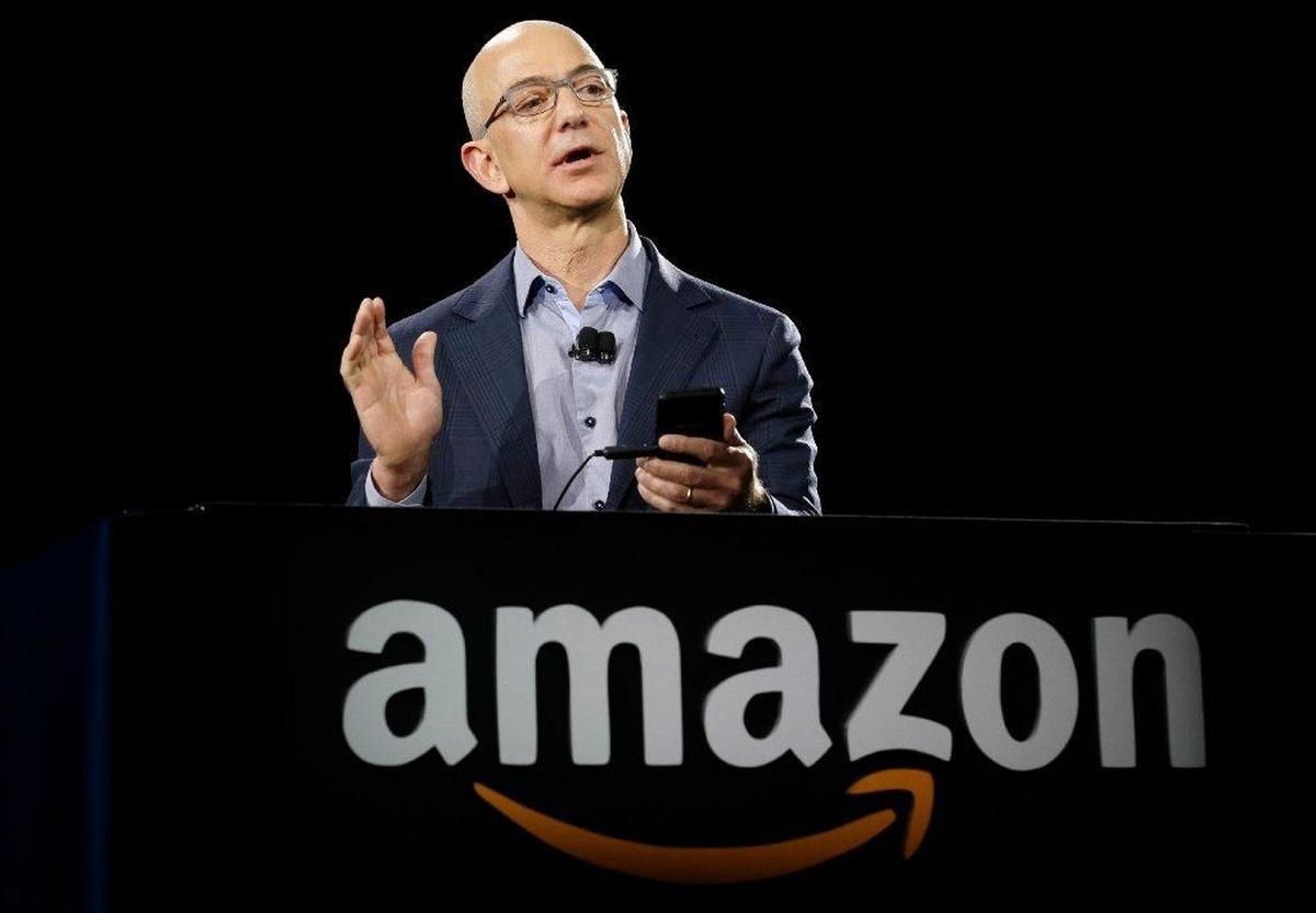 In this June 18, 2014, file photo, Amazon chief executive Jeff Bezos displays an Amazon Fire Phone in Seattle.