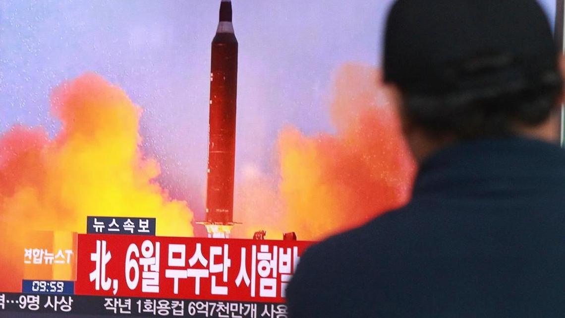 A man in South Korea watched a TV news program showing a missile launch conducted by North Korea. The caption reads, “North attempted to fire a mid-range Musudan missile in June.”