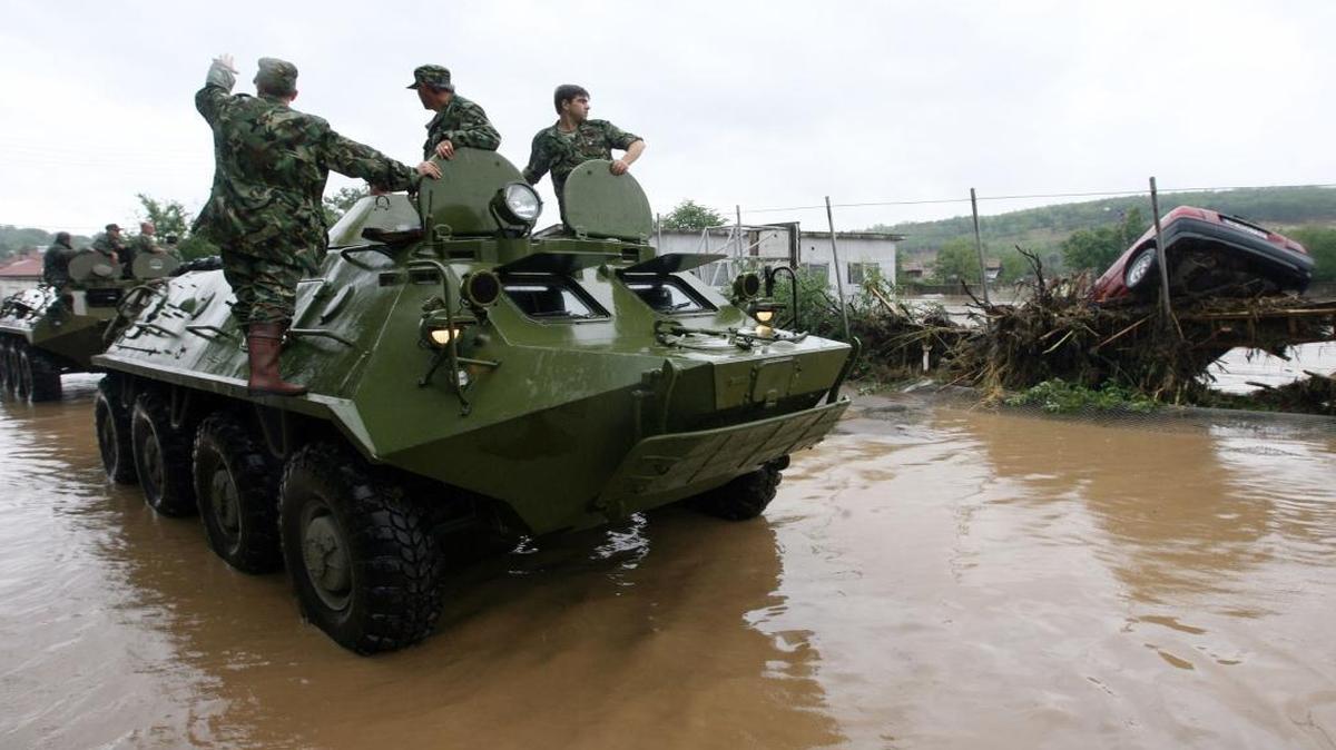 Bulgarian soldiers survey the area from atop a military vehicle during flooding in the town of Tzar Kaloyan, 260 kilometers (160 miles) east of the Bulgarian capital Sofia, Tuesday, Aug, 7, 2007. Torrential rain after weeks of drought caused severe flooding in northern Bulgaria, sweeping away cars, reducing dozens of homes to rubble and killing at least seven people.