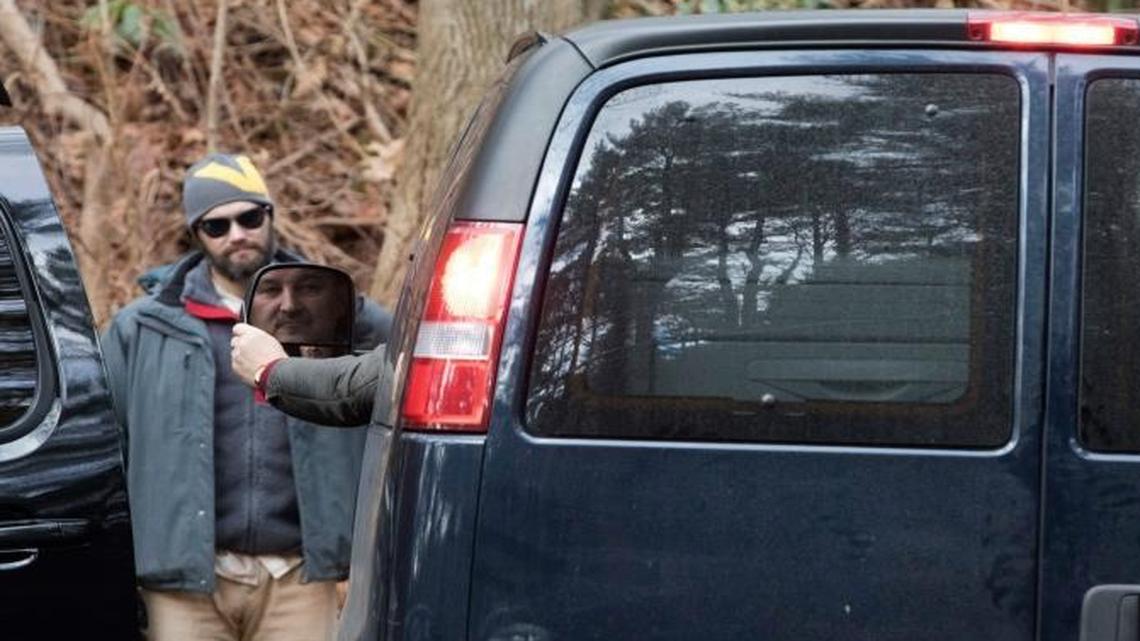 A man driving a van with diplomatic license plates hands his identification to U.S. special agents outside an estate in the town of Oyster Bay, N.Y., on Long Island on Friday. The compound was one of two the U.S. government closed to Russian diplomats in retaliation for what the Obama administration has said was cyber-meddling in the U.S. presidential election.