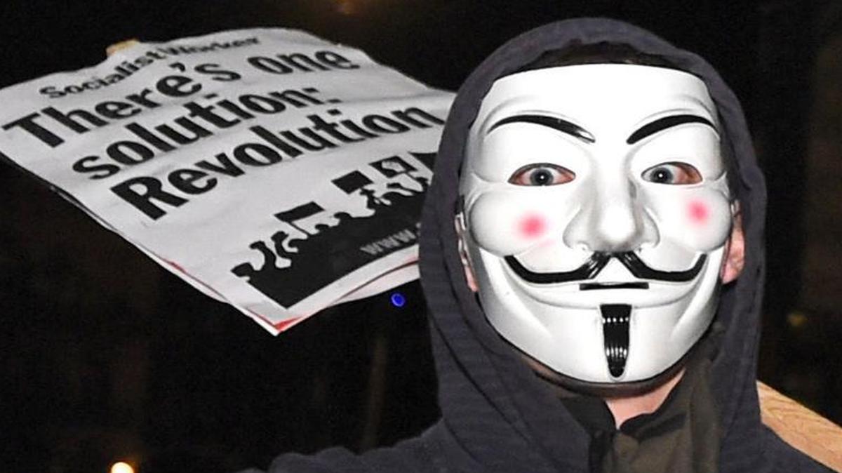 A protester joins others demonstrating near the Houses of Parliament in central London during the Million Mask March bonfire night protest organized by the activist group Anonymous, Nov. 5, 2016. The annual protest is one of many similar marches held worldwide on Nov. 5, broadly aimed at anti-capitalism and pro-civil liberty.
