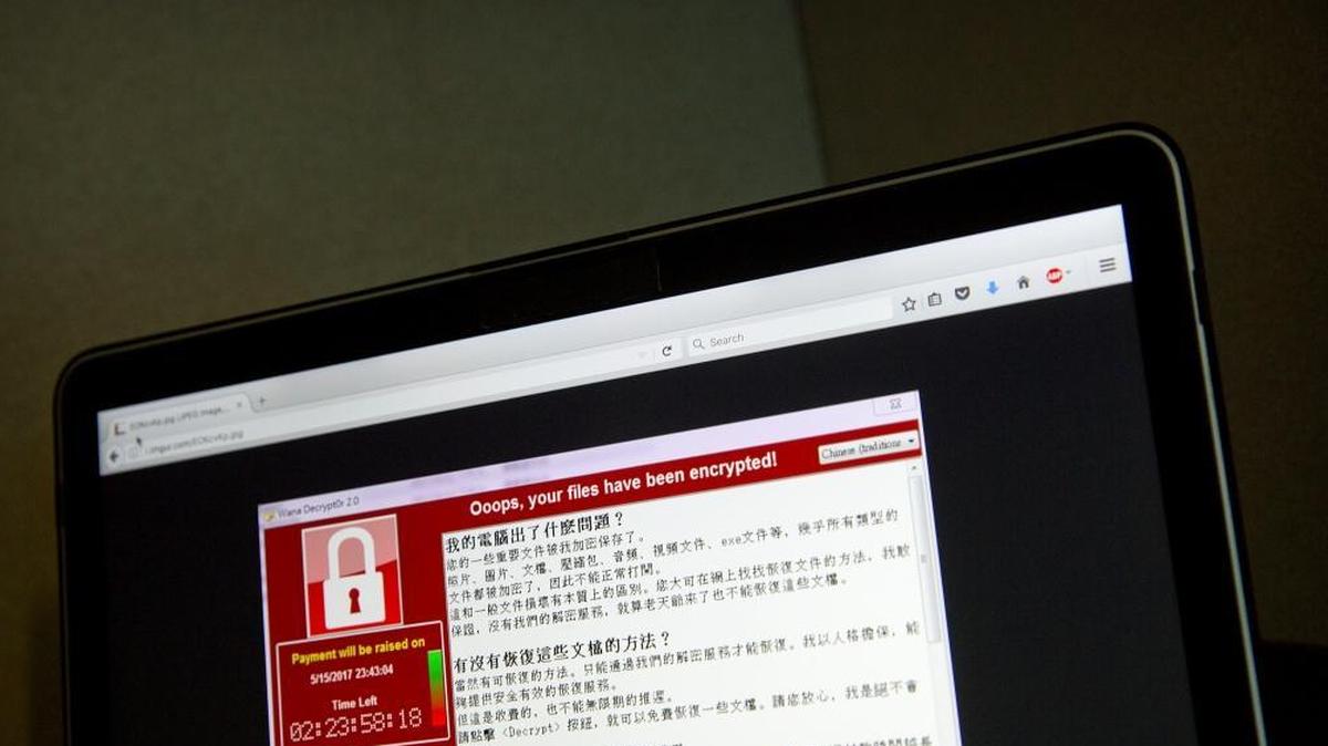 In this May 13, 2017, file photo, a screenshot of the warning screen from a purported ransomware attack, as captured by a computer user in Taiwan, is seen on a laptop in Beijing. May and June global cyber attacks have cost corporations more than $1.2 billion in lost revenue.