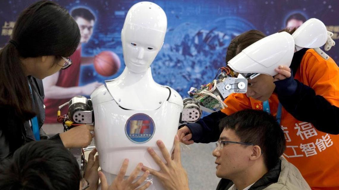 Chinese students work on the Ares, a humanoid bipedal robot designed by them with funding from a Shanghai investment company, displayed during the World Robot Conference in Beijing on Oct. 21, 2016. China's goal is to transform the country into a global leader in artificial intelligence in just over a decade.