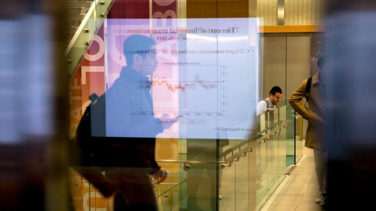 The slide of a chart being used in the course "Digital Currenty, Blockchains, and the Future of the Financial Services Industry” is reflected in an auditorium window leading to a hallway, at New York University in New York, Jan. 29, 2018.