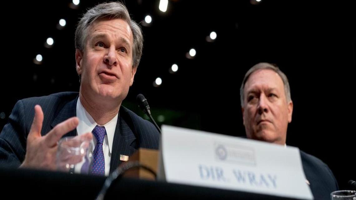 FBI Director Christopher Wray, accompanied by CIA Director Mike Pompeo, right, speaks at a Senate Select Committee on Intelligence hearing on worldwide threats, Tuesday, Feb. 13, 2018, in Washington.