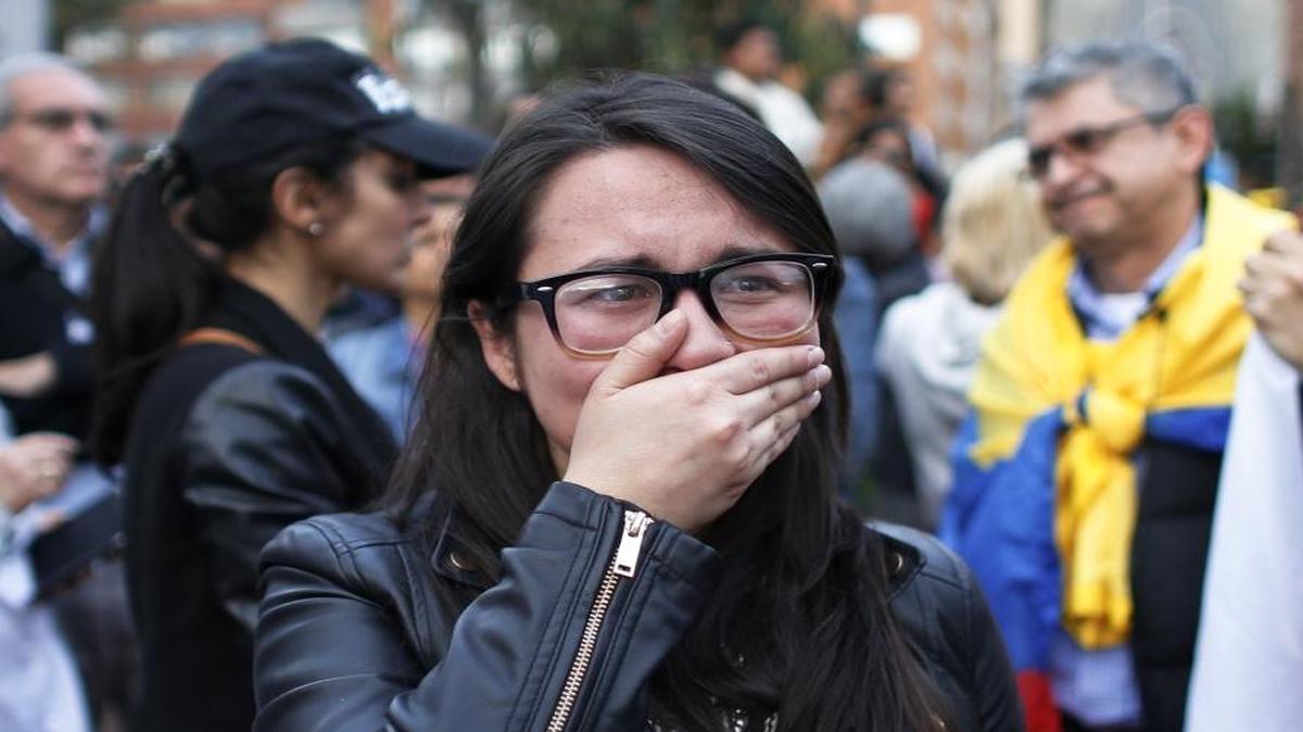A supporter of the peace accord signed between the Colombian government and rebels of the Revolutionary Armed Forces of Colombia, FARC, cries as she follows on a giant screen the results of a referendum to decide whether or not to support the deal in Bogota on Sunday, Oct. 2, 2016. Colombians rejected the deal by a razor-thin margin.