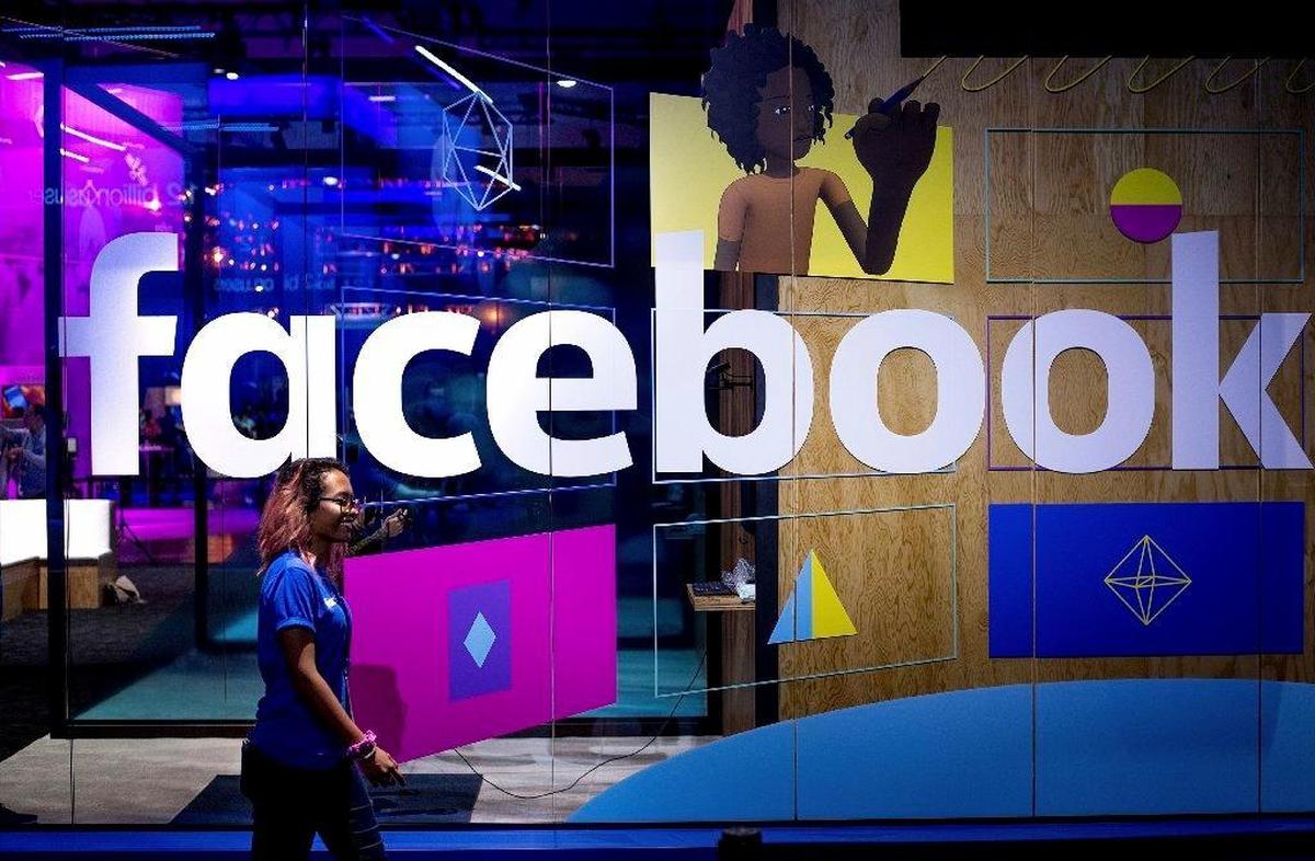 Conference workers speak in front of a demo booth at Facebook’s annual F8 developer conference in San Jose, California, on April 18, 2017.