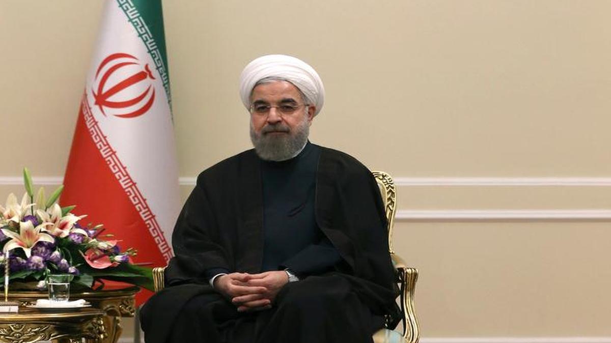
Iranian President Hassan Rouhani, beneath portraits of the late Iranian revolutionary founder Ayatollah Khomeini and current Supreme Leader Ayatollah Ali Khamenei. 
