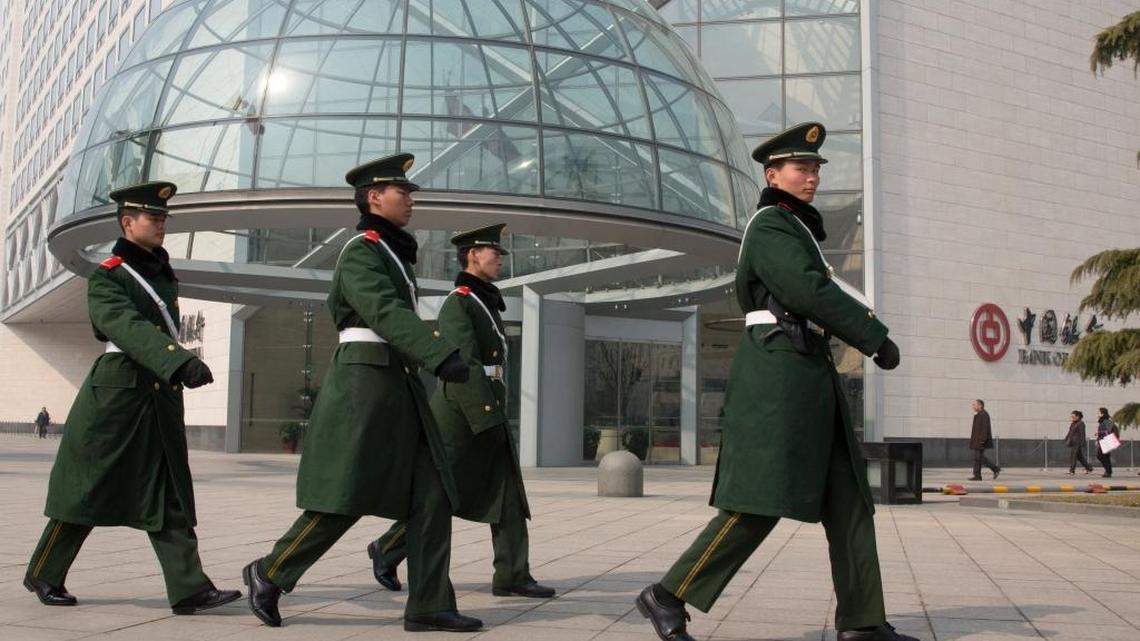 Paramilitary police patrol near the headquarters of the Bank of China in Beijing. U.S. cybersecurity researchers say they detect an uptick in Chinese hacking of corporations in the United States.