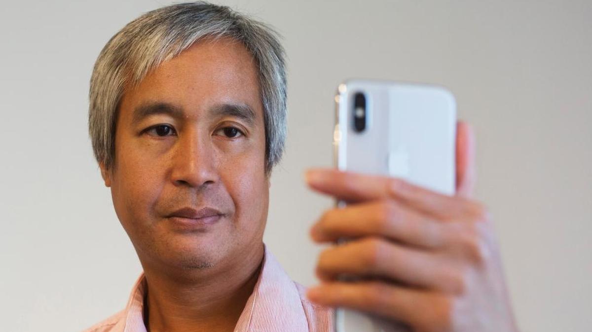 Associated Press reporter Anick Jesdanun demonstrates Face ID, Apple's name for its facial-recognition technology, on an iPhone X in New York.