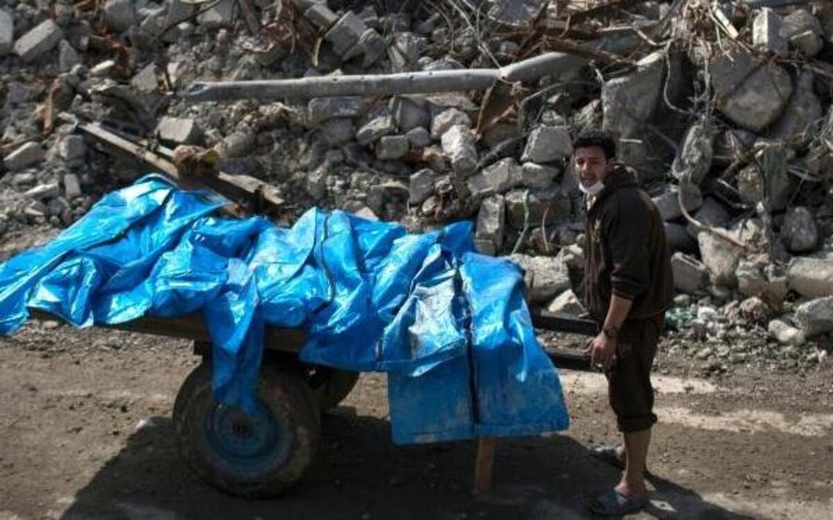 A resident pushes a cart loaded with the bodies of six people killed during fights between Iraqi security forces and the Islamic State on the western side of Mosul on Friday, March 24, 2017. Scores of residents of the Mosul Jidideh neighborhood are thought to have died in U.S. airstrikes that hit a cluster of homes in the area.