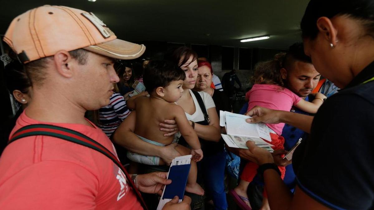 A migration officer checks the documents of Cuban migrants before they board a chartered flight in Panama City in May. U.S. officials are urging Latin American governments to stem the tide of Cubans who travel through South and Central America to reach the United States.