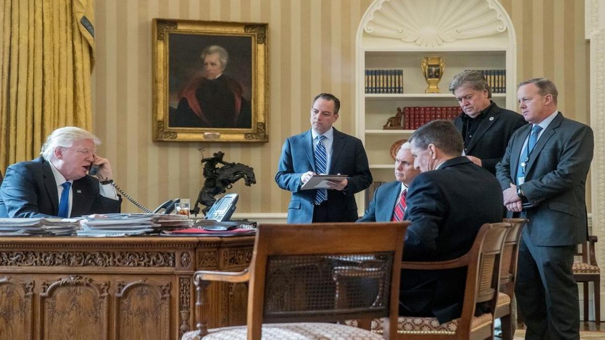 White House senior adviser Steve Bannon, second from right, in black suit, listens as President Donald Trump speaks on the phone with Russian President Vladimir Putin, Saturday, Jan. 28, 2017, in the Oval Office at the White House. Trump also is accompanied by, from second from left, Chief of Staff Reince Priebus, Vice President Mike Pence, National Security Adviser Michael Flynn and White House Press Secretary Sean Spicer.