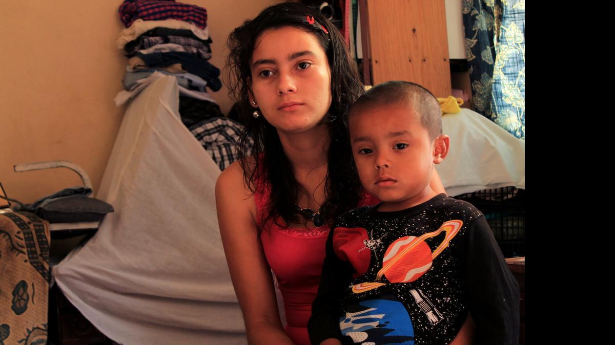 
Lilian Oliva Bardales, aged 19, sits with her son, Christian, aged 4, in the small living room of a relative’s house on June 15, 2015.
