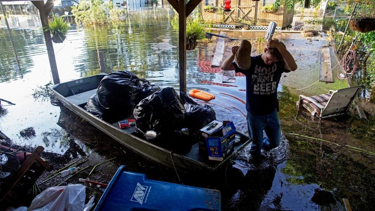 Daniel Stover, 17, wipes his head as he helps Laura Albritton, rescue personal belongings in Sorrento, Louisiana, on Aug. 20. Louisiana continues to dig itself out from devastating floods, with search parties going door to door looking for survivors or bodies trapped by flooding.