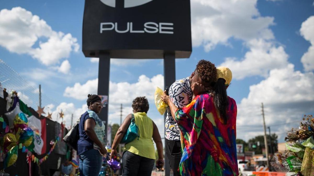 FILE – Wayne Dominici, 23, cries on the shoulder of his aunt, Ada Dominici, at a memorial outside Pulse, the gay nightclub where a shooter killed 49 and wounded many more, in Orlando, Fla. A recent Penn State University political poll shows Democrats responded with more anger than Republicans over the shooting.