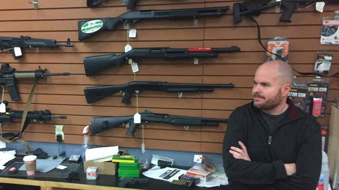 Firearms salesman Nathan Williams, 37, of Albuquerque, attends to customers at The Outdoorsman gun shop in Santa Fe, N.M., on Jan. 5, 2017.