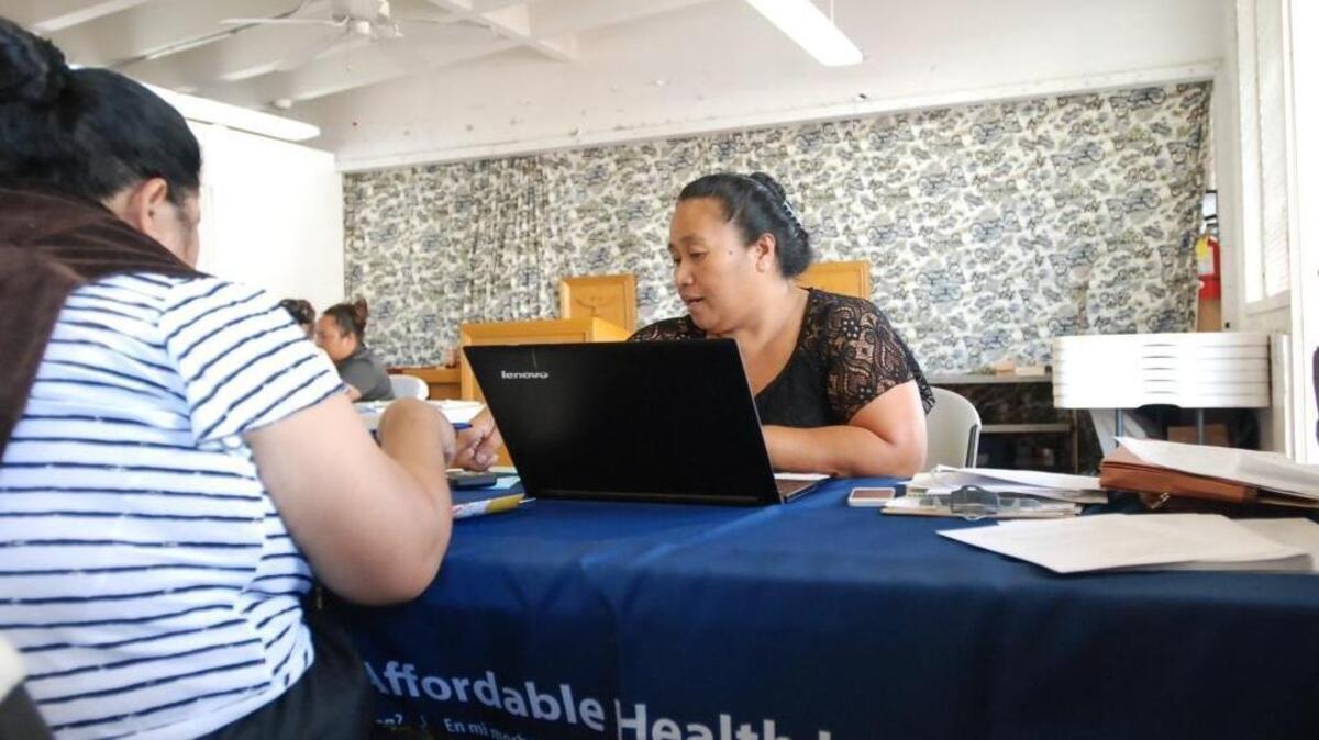 Cinder Sonis, right, an advocate with Legal Aid Society of Hawaii, helped a customer enroll in an Affordable Care Act health insurance plan on Monday, Jan. 30, 2017 in Honolulu. new government figures show 500,000 fewer people enrolled in marketplace coverage in 2017. (AP Photo/Cathy Bussewitz)