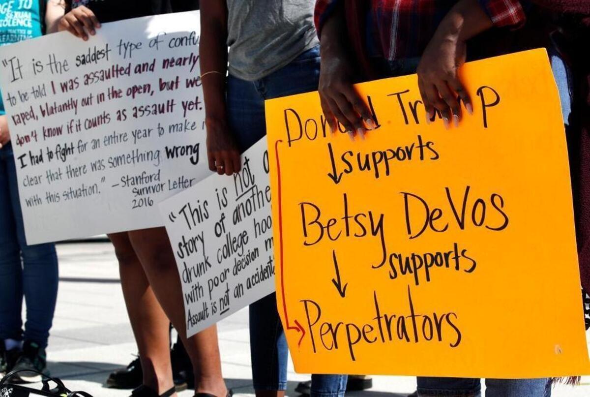 People gather to protest proposed changes to Title IX before a speech by Education Secretary Betsy DeVos, Thursday.