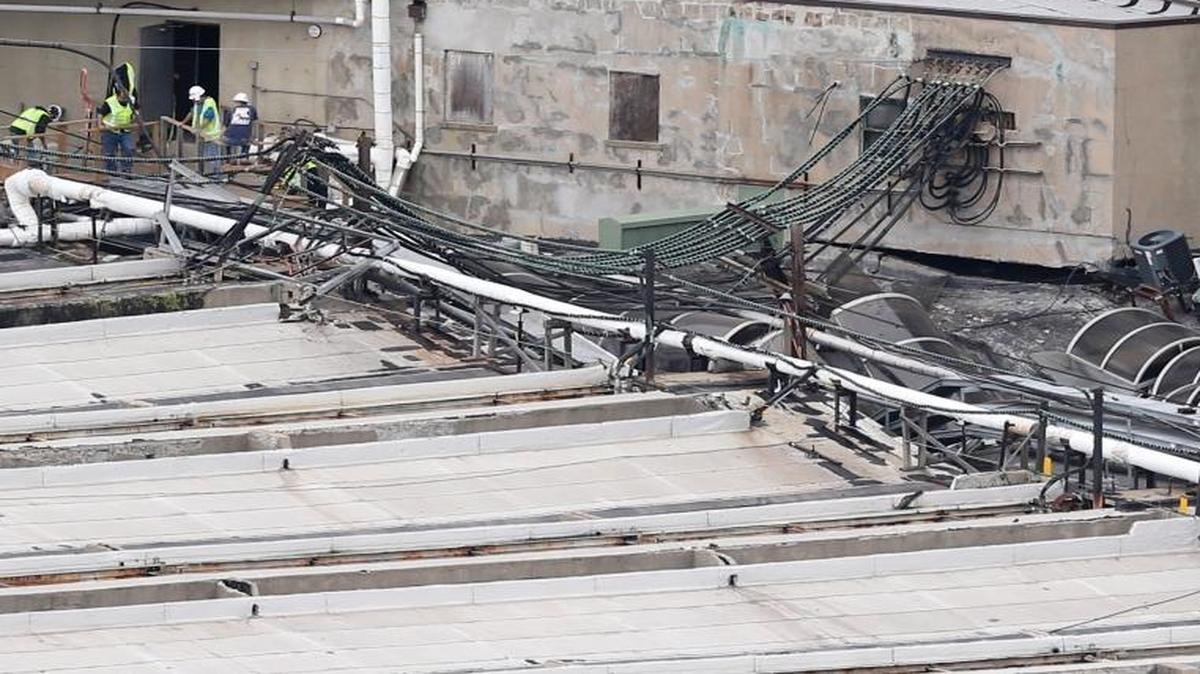 Workers inspect damage on a section of the roof of the Hoboken station as seen from Jersey City, N.J., Thursday, Sept. 29, 2016. A crowded commuter train plowed into the bustling station during the morning rush hour Thursday, injuring more than 100 in a tangle of broken concrete, twisted metal and dangling cables, authorities said.