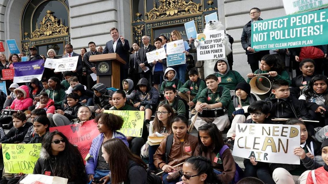 Acting San Francisco Mayor Mark Farrell, at podium, speaks at a rally for clean energy in San Francisco, Wednesday, Feb. 28, 2018. A U.S. District Court in San Francisco will be the setting for a first-ever hearing on the science of climate change, scheduled for March 21 by William Alsup, a federal judge.