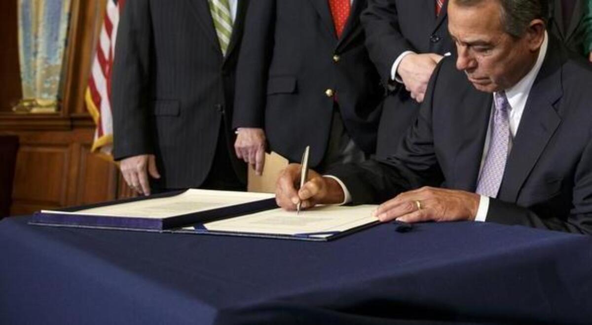 House Speaker John Boehner, seated, and Senate Majority Leader Mitch McConnell, second from left, must deal with a host of serious fiscal deadlines in short order when Congress returns Tuesday from its August recess. In this Feb. 13, 2015 photo, Boehner signs the bill authorizing expansion of the Keystone XL pipeline.