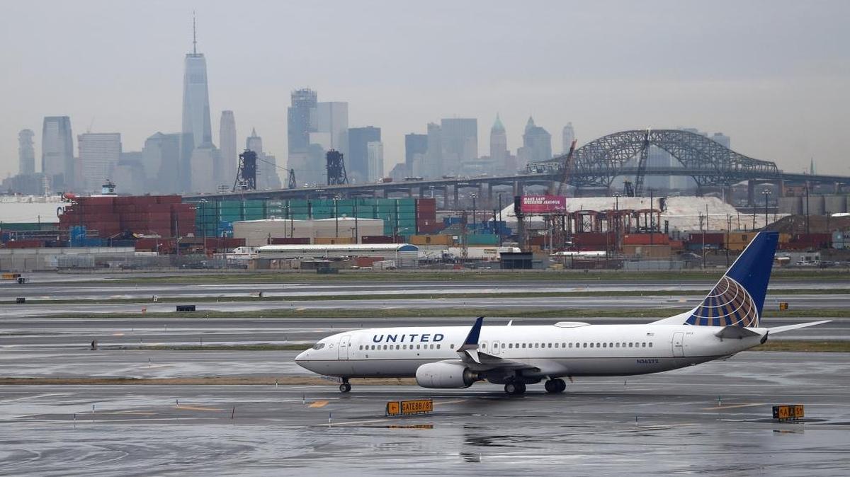 The New York skyline looms in the background as a United Airlines plane taxis at Newark Liberty International Airport on Wednesday, April 12, 2017, in Newark, N.J.