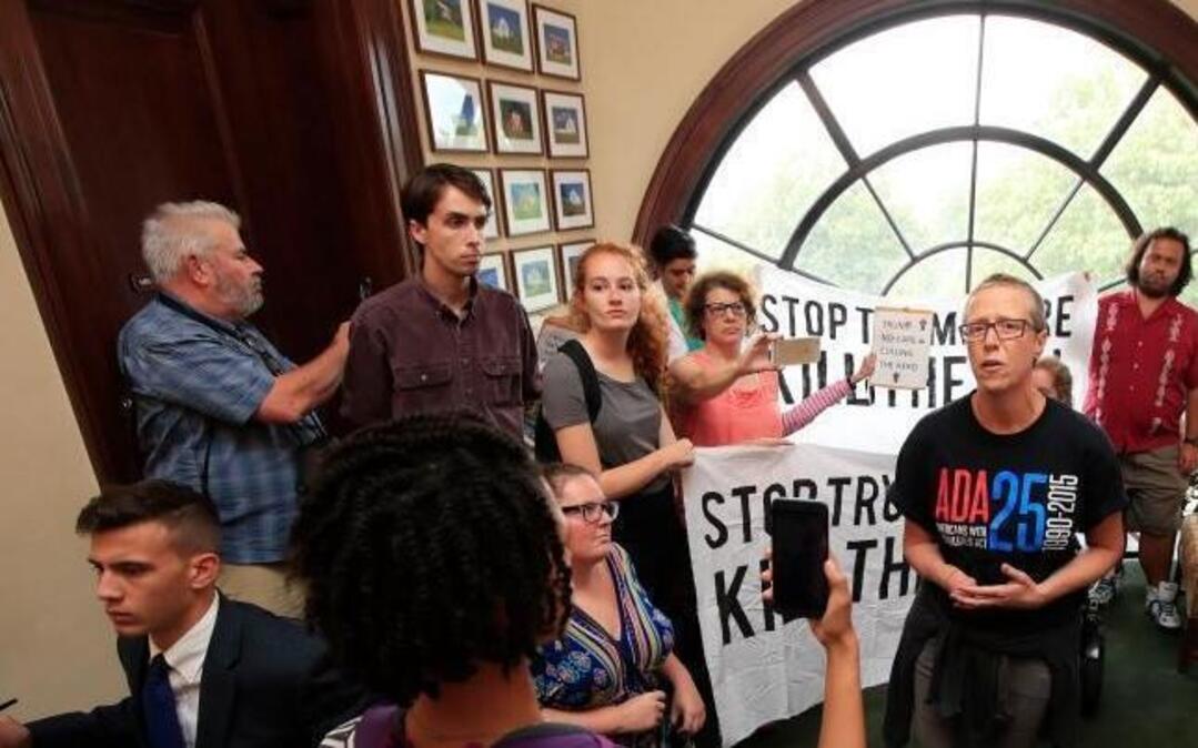 Protesters against the Republican health care bill are gathered inside the office of Sen. Rob Portman, R-Ohio, on Capitol Hill in Washington, Monday.