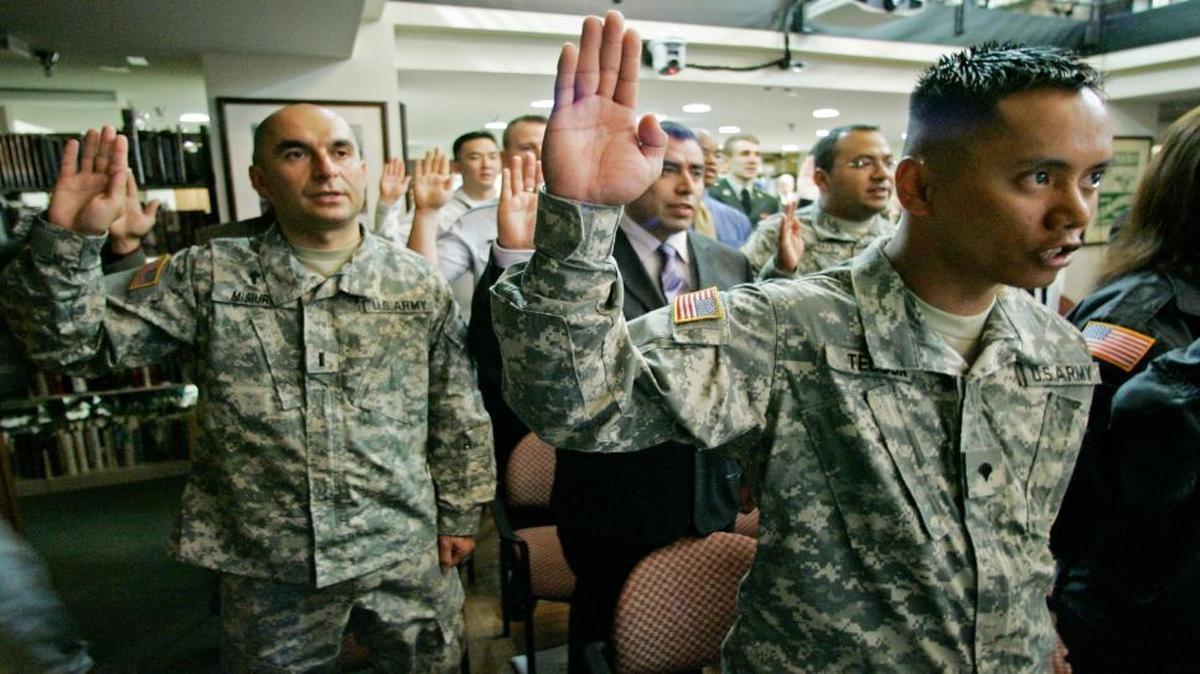 U.S. Army Reserve Lt. Krzysztof Misiura, formerly of Poland, left, and USAR Specialist Christian Joy Tecson, formerly of the Philippines, right, take the Oath of Allegiance along with 28 other members of the U. S. Armed Forces Friday, May, 23, 2008 as they become U.S. Citizens during a ceremony at the Pritzker Military Library in Chicago.